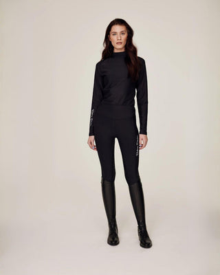 Full body front view of the black equestrian top and riding tights, showcasing the fast-drying and dirt-repellent material.