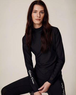 Sitting model wearing the complete black riding set, highlighting the white "Riders Denim" logo on the sleeve.