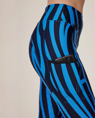Close-up of the phone pocket on the right thigh, featuring the anti-slip silicone logo on the blue zebra fabric.
