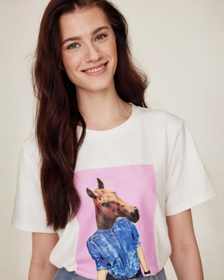 Close-up portrait of a smiling model wearing the white horsie print t-shirt, showing a warm and friendly equestrian style.