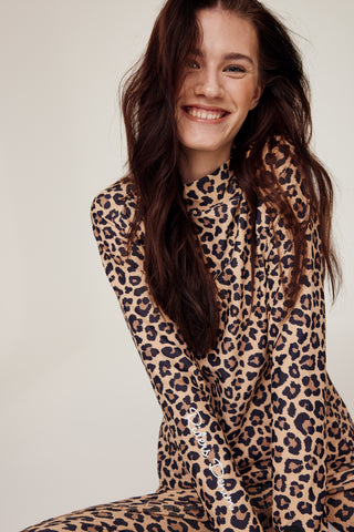 Skrattande modell sittande med det kompletta ridsetet med leopardmönster från Riders Denim.