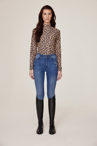 Frontbild i helkropp av en modell som visar upp Leo-ridtoppen tillsammans med original-riddenimbyxor.